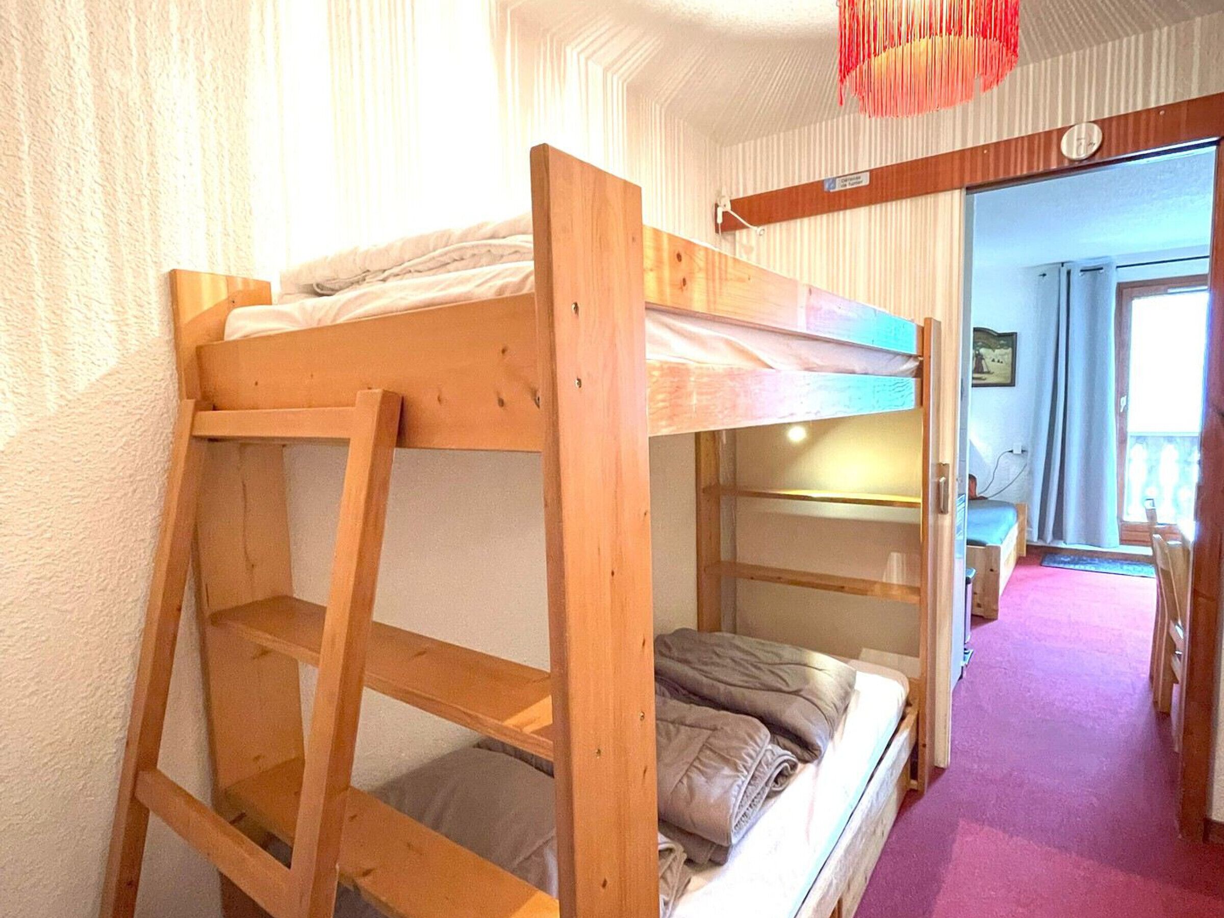 Dormitorio con literas, un escritorio y una silla.