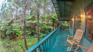 A wooden deck with rocking chairs overlooking a lush forest. - 6 mins from Nat'l Park! Enjoy the sound of rain & birds in a peaceful retreat. (Volcano)