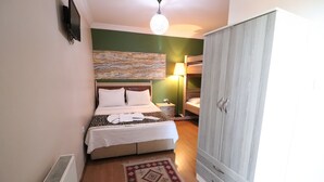 A bedroom with a bed, a bedside table, a lamp, a wardrobe, and a radiator.