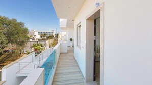 A narrow balcony with a pool, white walls, and a clear view of the surrounding buildings. - Absolute Suite Apartments (Porto Cesareo)