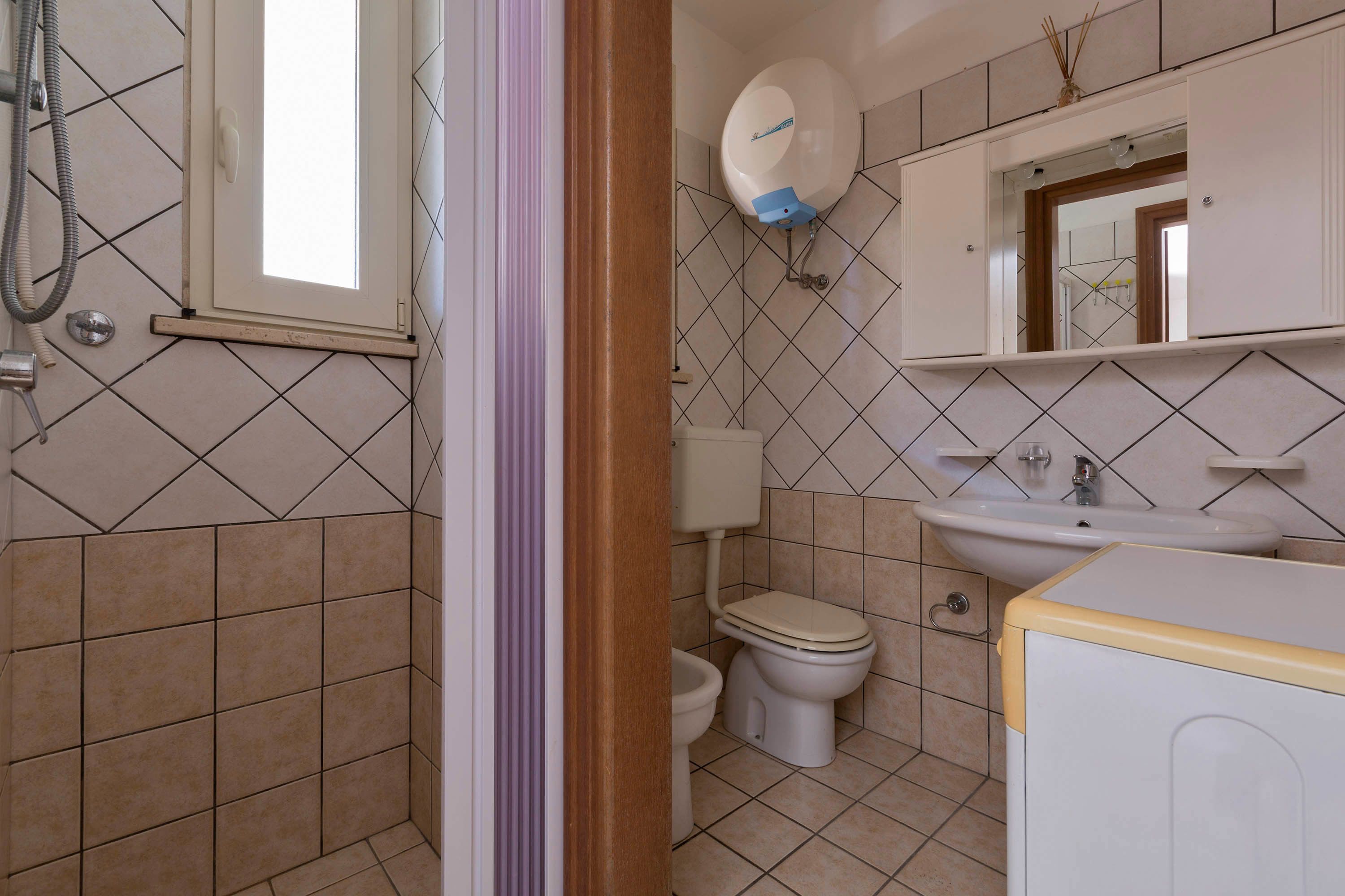 A bathroom with a toilet, sink, and shower.