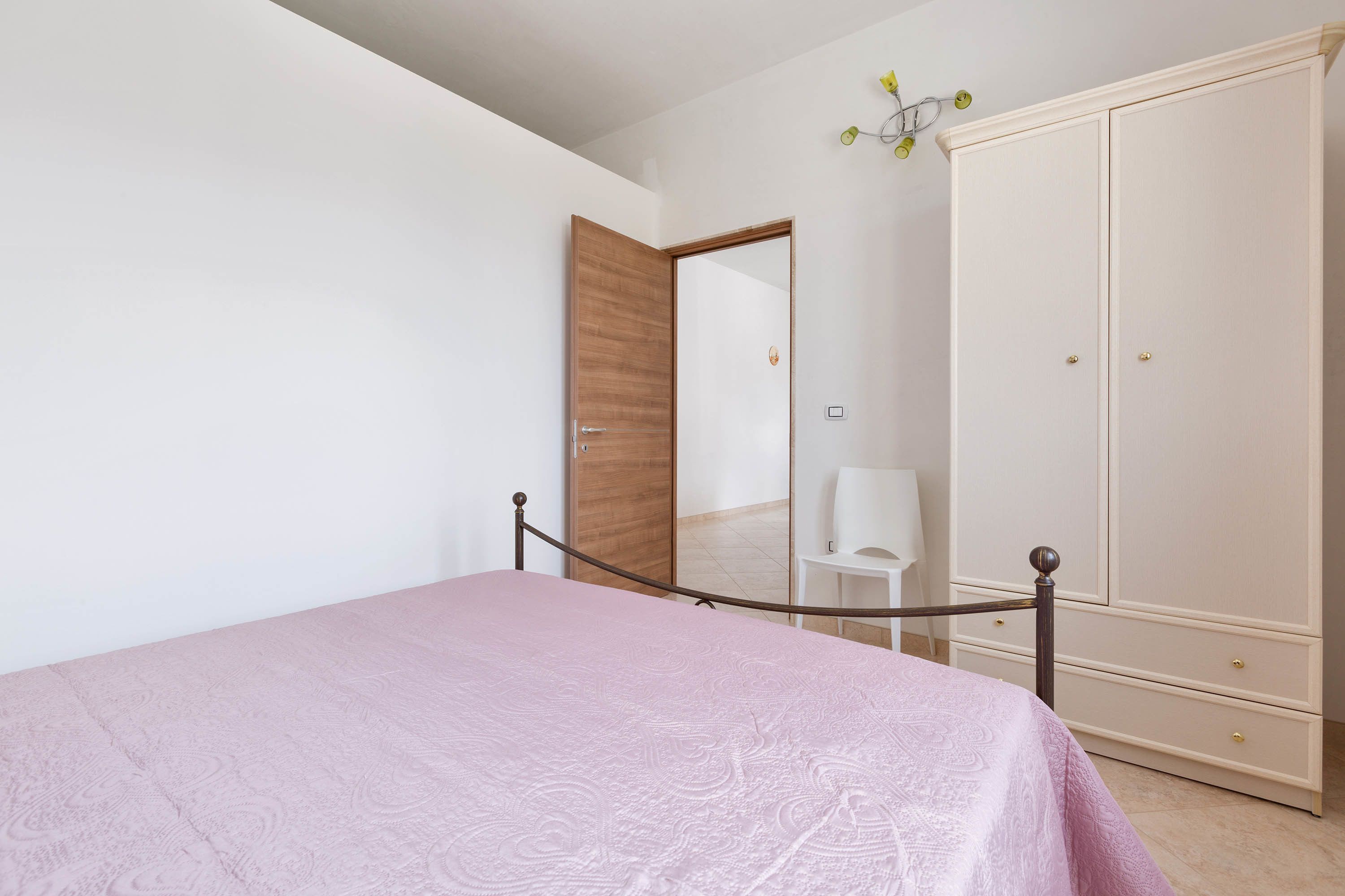 Une chambre à coucher avec un lit, une armoire et un miroir.