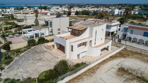 A modern white building with a flat roof and a small patio area. - Residence Tabù (Porto Cesareo)
