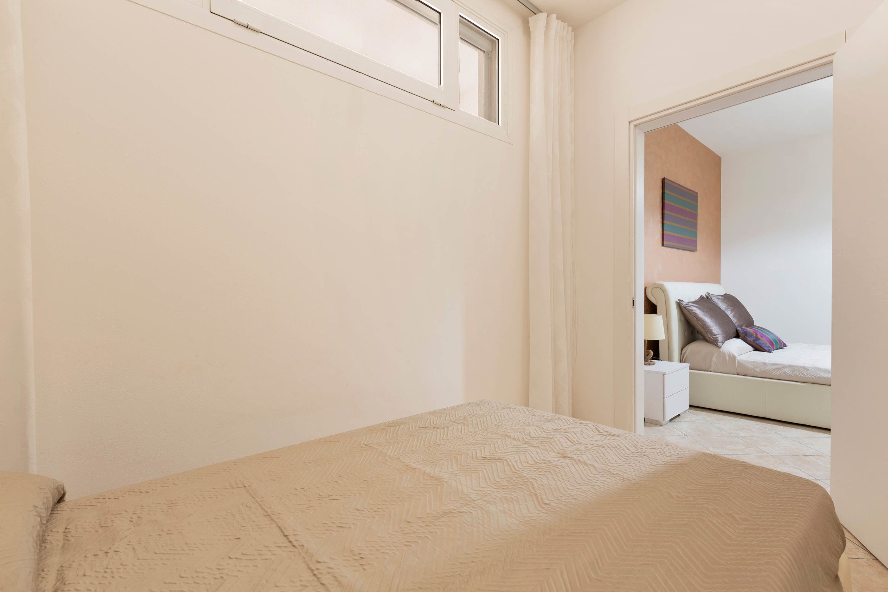 Un dormitorio con una cama, una mesita de noche, una lámpara y un cuadro en la pared.