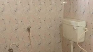 Une petite salle de bain avec des toilettes, une douche et une fenêtre.