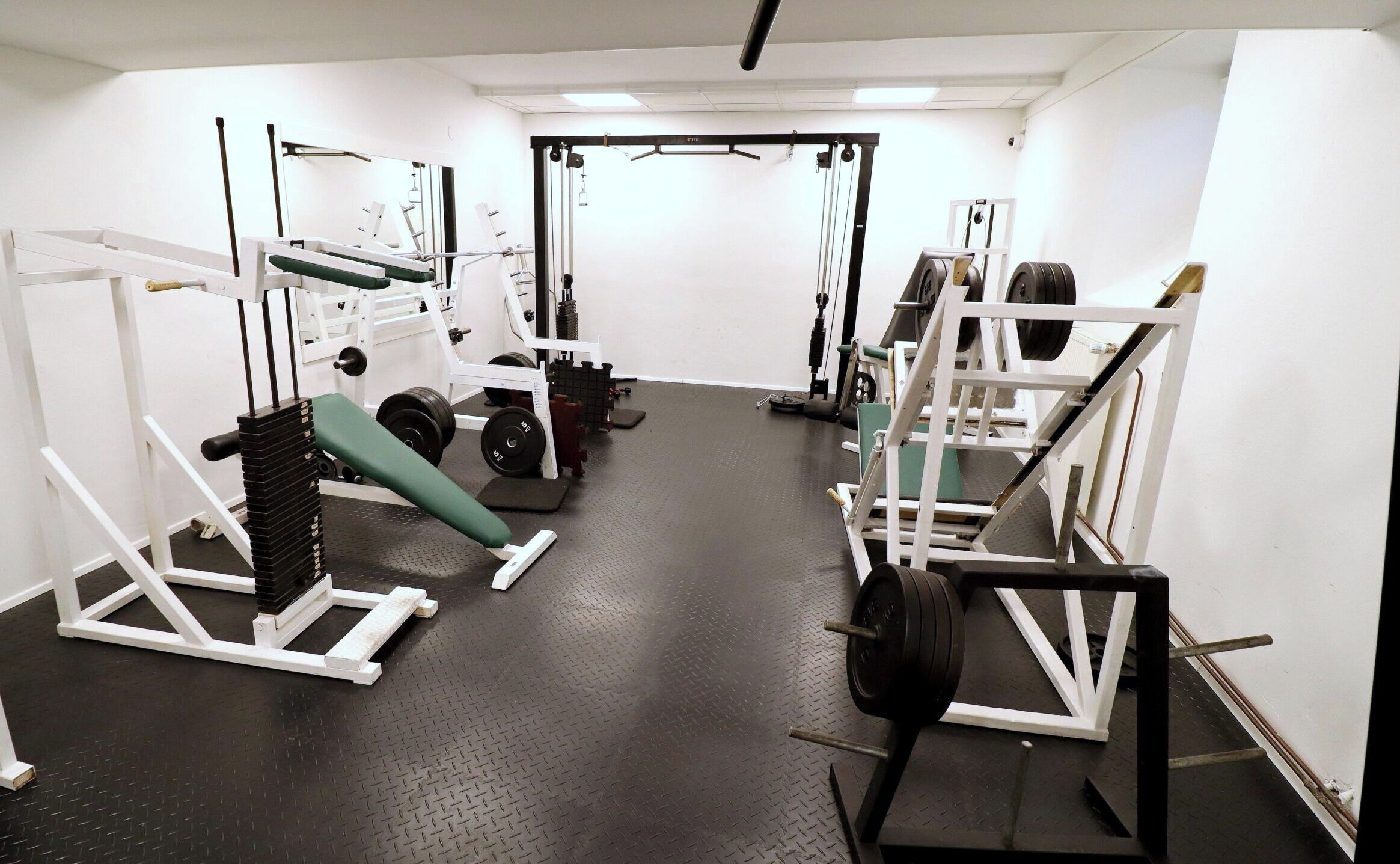 A gym with various exercise equipment, including weight machines and free weights.