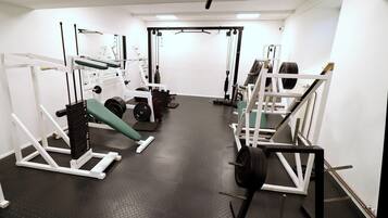 A gym with various exercise equipment, including weight machines and free weights.