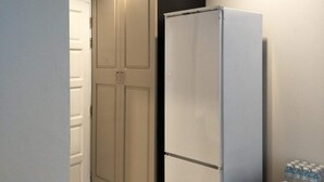 A compact kitchen with a refrigerator, a cabinet, and a countertop. - The 92 residence (Bangkok)