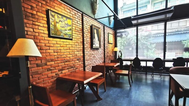 A restaurant with brick walls, wooden tables, and chairs. - The 92 residence (Bangkok)