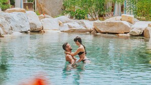 A couple in a natural pool surrounded by rocks and greenery. - Hotel Corte Bianca, Bovi's Hotels - Adults Only (Cardedu)