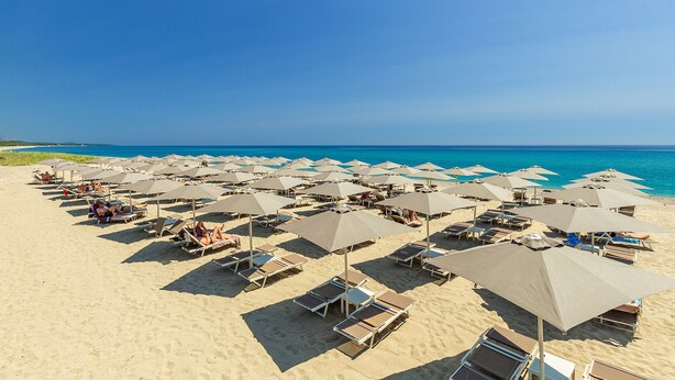 A beach with rows of sun loungers and umbrellas, a clear blue sky, and the ocean in the background. - Hotel Corte Bianca, Bovi's Hotels - Adults Only (Cardedu)