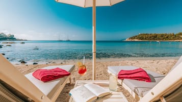 Privatstrand, weißer Sandstrand, Liegestühle, Sonnenschirme