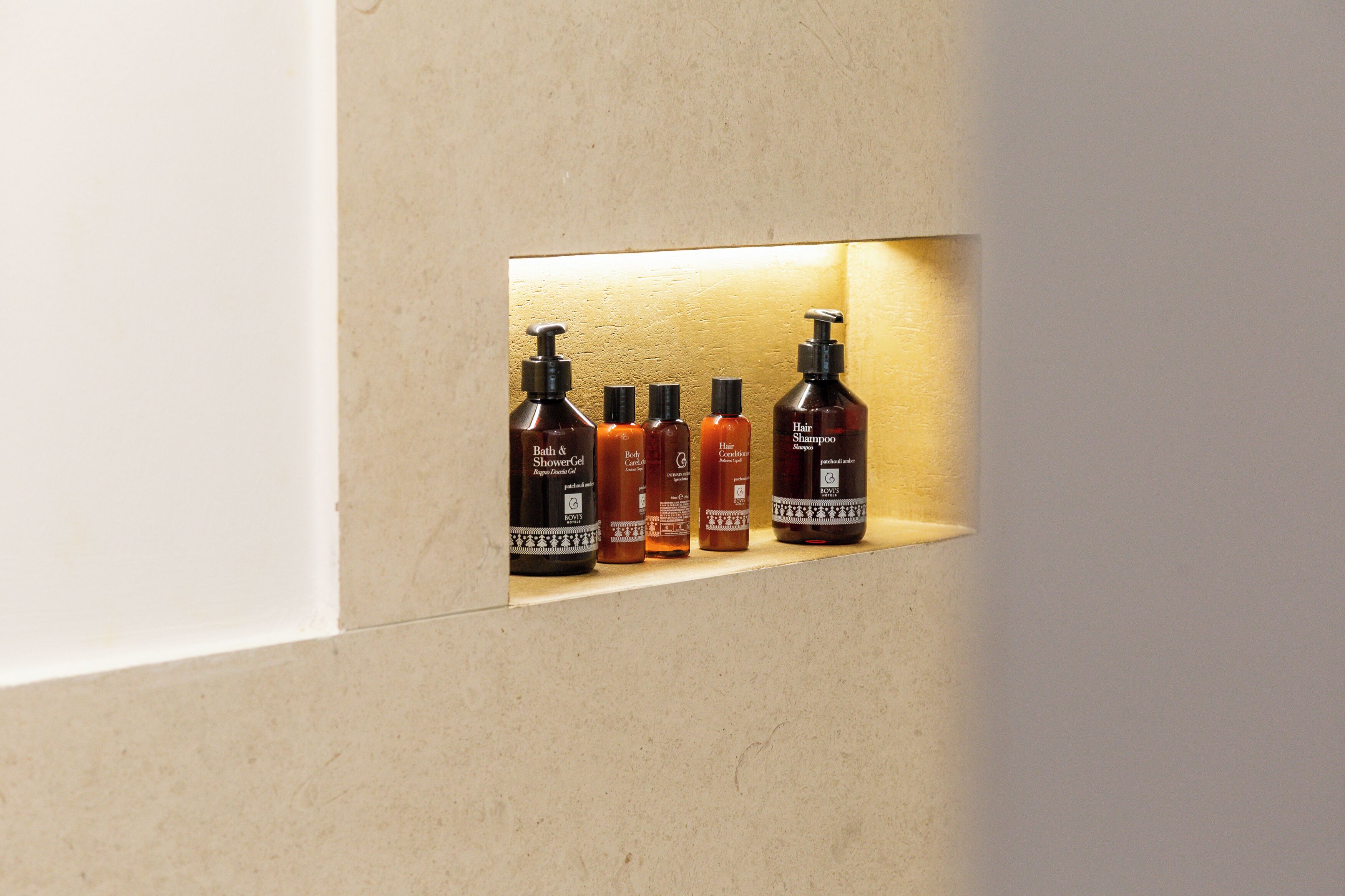 Una estantería con cinco botellas de productos para el cabello.