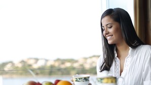 Une table à manger avec un panier de fruits, une théière et une tasse.