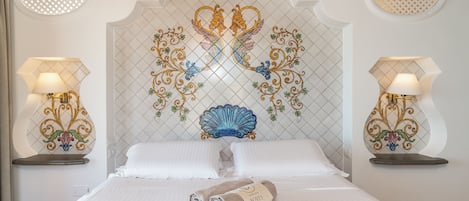 Una habitación de hotel con una cama grande, dos mesitas de noche con lámparas y un panel decorativo en la pared.
