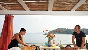 Une séance de massage dans une salle offrant une vue sur la mer.