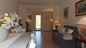 A living room with a dining table, a sofa, and a lamp. There is a door leading to a balcony. - Casa Marcoiano (Scarperia e San Piero)