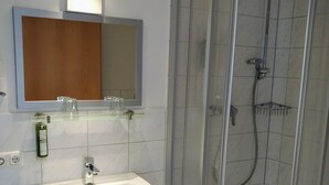 Une salle de bain avec une douche à parois de verre, un lavabo et un miroir au-dessus.