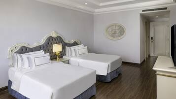 Une chambre d’hôtel avec deux lits, un ventilateur de plafond, une horloge et un téléviseur.