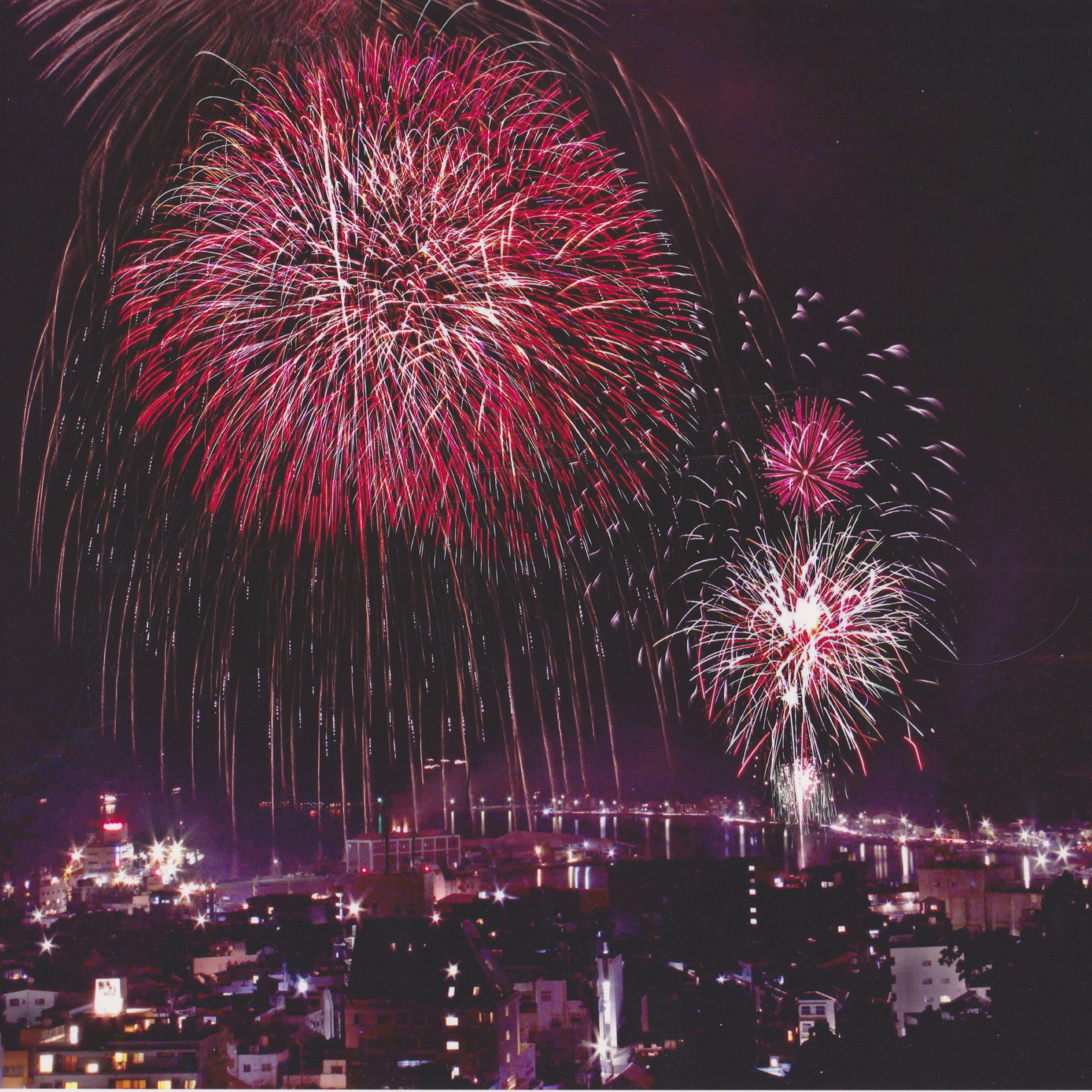 A nighttime cityscape with fireworks display.