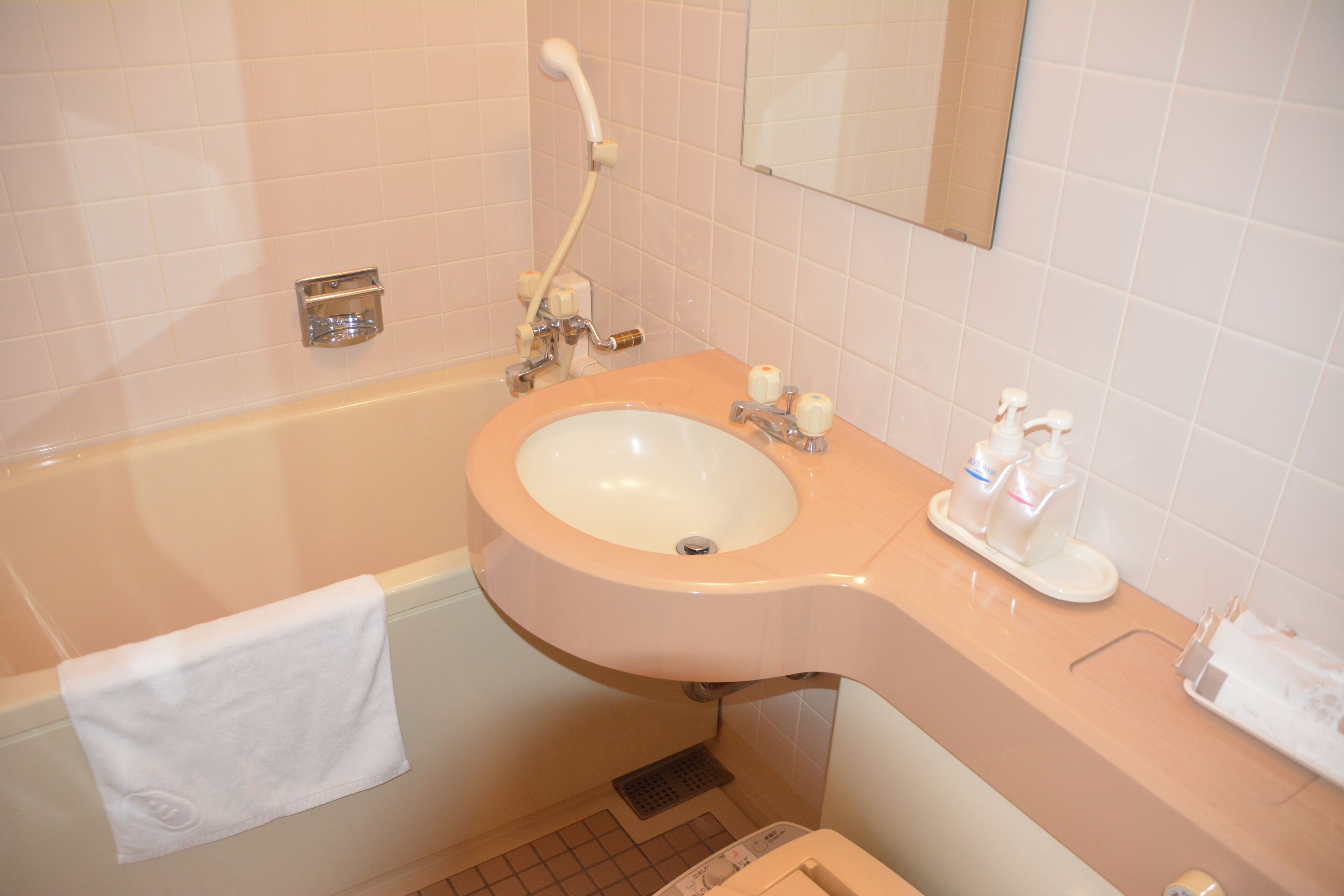 Un baño con bañera, lavabo y espejo.