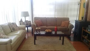 A living room with a sofa, a coffee table with decorative items, and a fireplace. - Casa en Condominio Terramar Maitencillo (Puchuncavi)