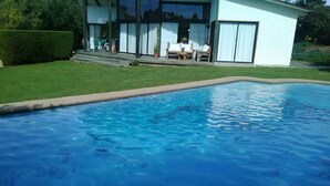 A swimming pool with a house in the background. - Casa en Condominio Terramar Maitencillo (Puchuncavi)
