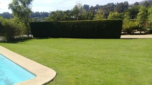 A well-maintained lawn with a neatly trimmed hedge and a swimming pool. - Casa en Condominio Terramar Maitencillo (Puchuncavi)
