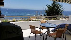 A balcony with wicker chairs and a table, overlooking the ocean. - Departamento Mares de Concon (Concon)
