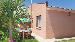 Un petit bâtiment doté d’un patio, d’une table et de chaises.