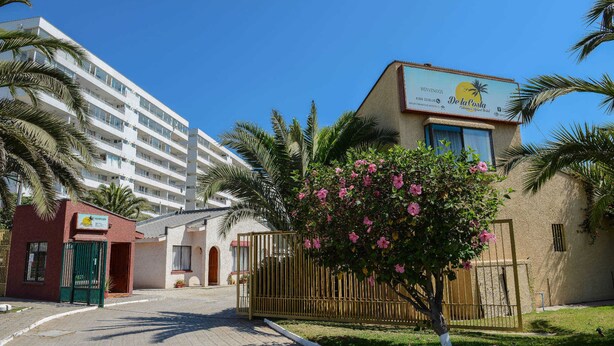 Un hôtel avec une enseigne indiquant « De la Costa » et un bâtiment doté de nombreux balcons.