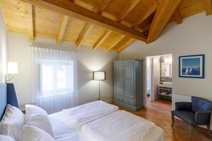 A bedroom with two beds, a wardrobe, a chair, a lamp, and a painting on the wall. - Villa Padovani (Pastrengo)
