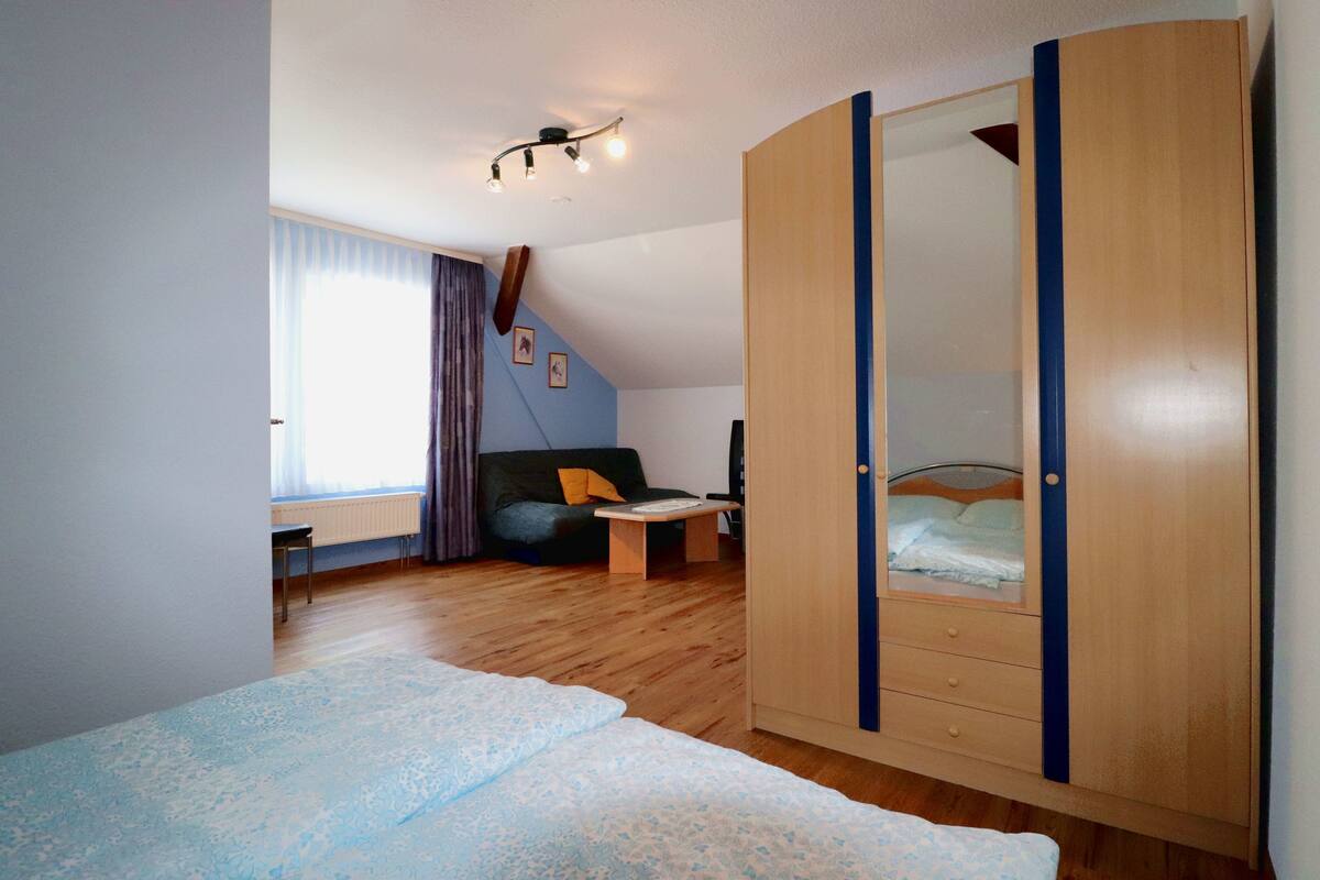 Une chambre à coucher avec un lit, une armoire, un bureau et une chaise.