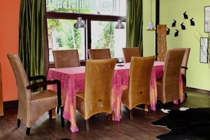 A dining area with wicker chairs and a table covered with a pink tablecloth. - Hotel Donnersberg (Darmstadt)