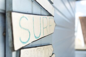 Une vue rapprochée d’une planche de surf sur laquelle est écrit le mot « SURF ».