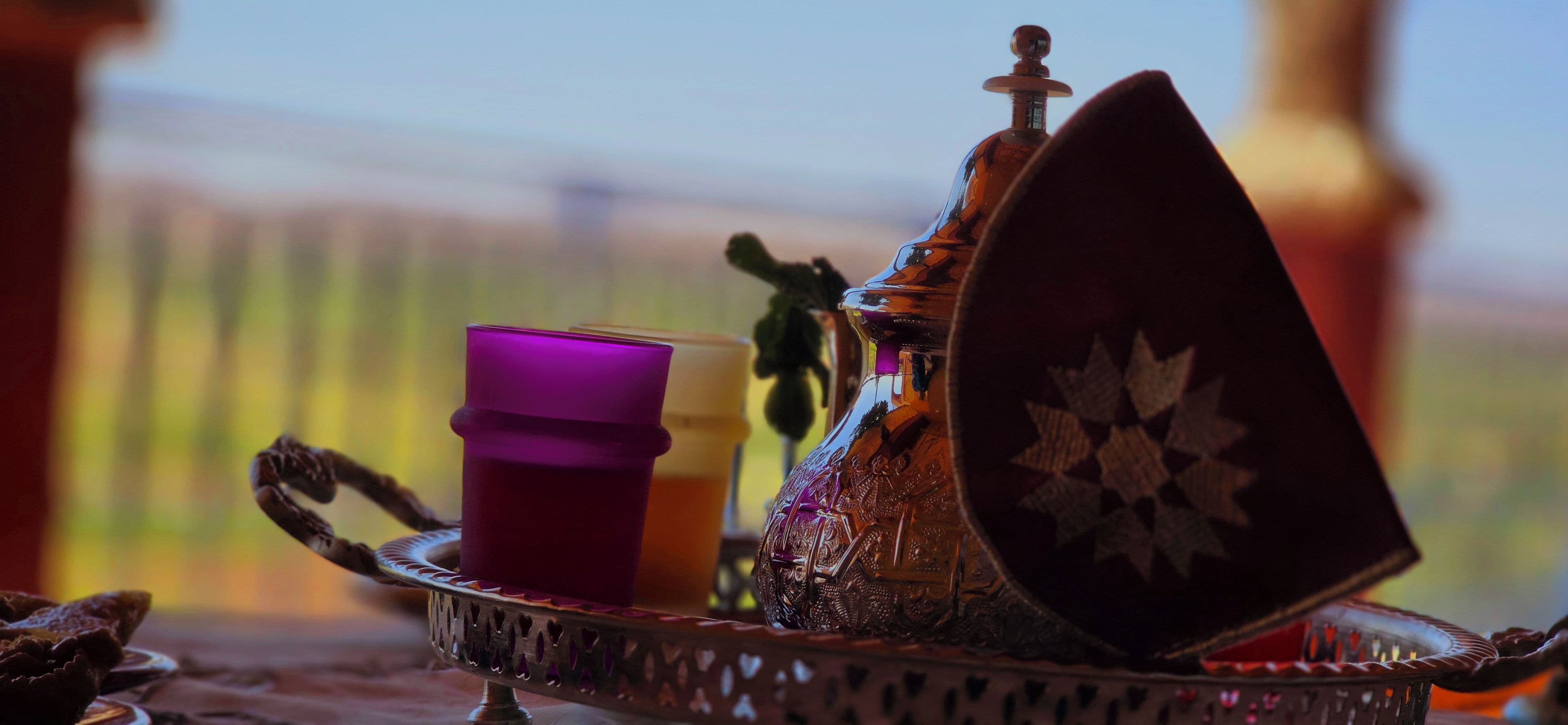 A tray with a teapot, a cup, and a decorative plate.