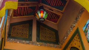 Una habitación con techo de madera, un farol de colores y paneles de madera decorativos.