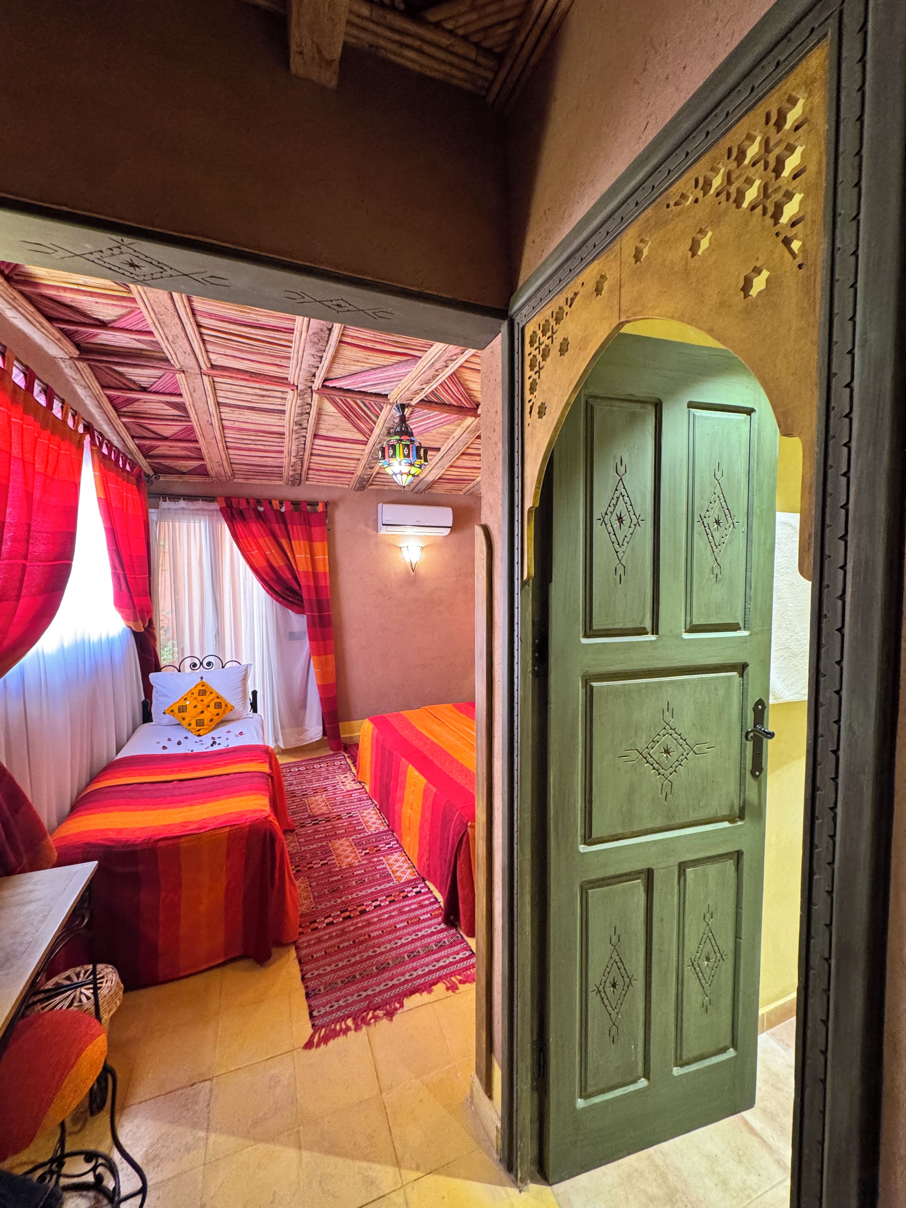 Una habitación con una cama, un escritorio y una puerta.