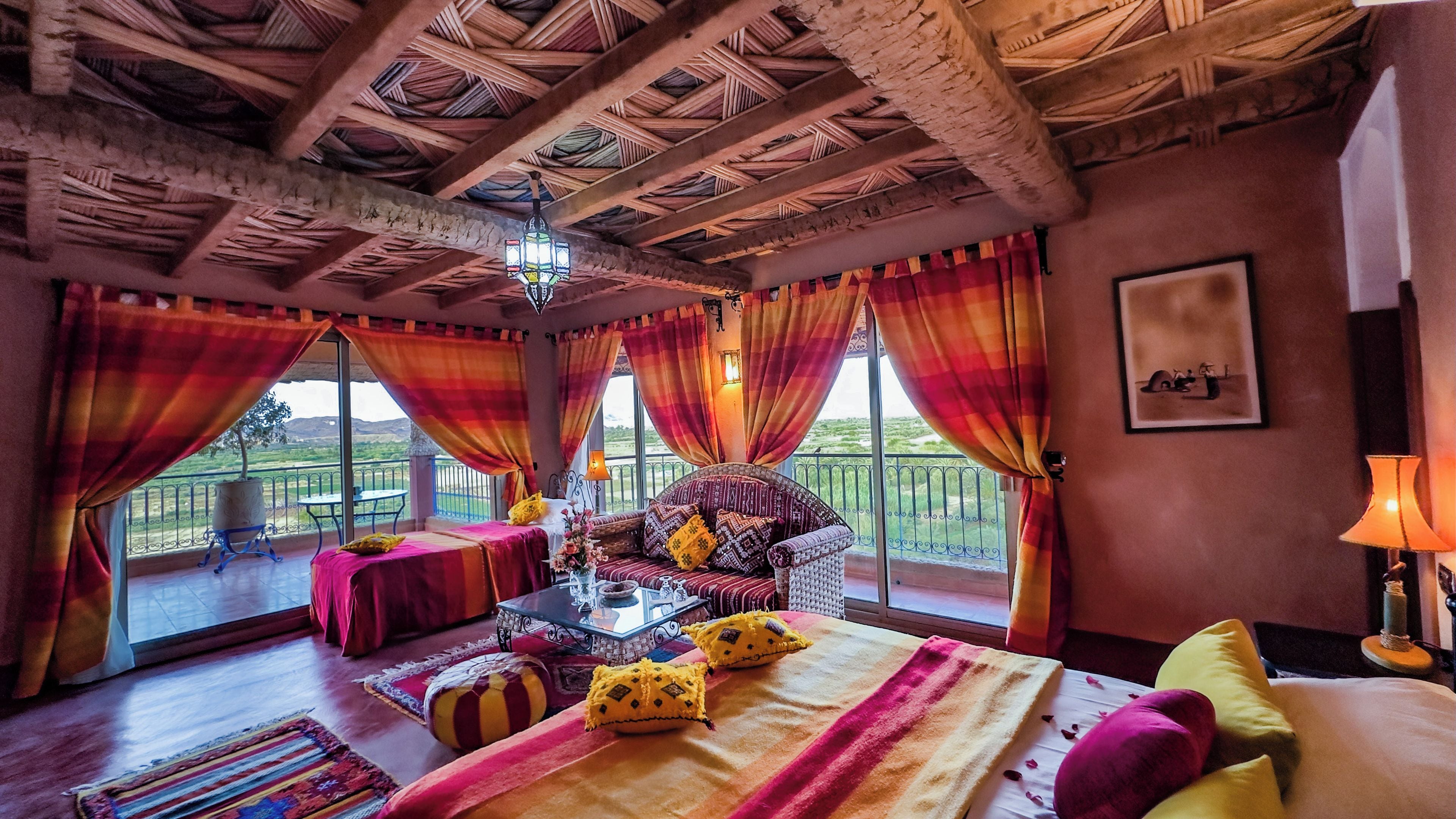 Una habitación con cama, una mesa y balcón con vistas.