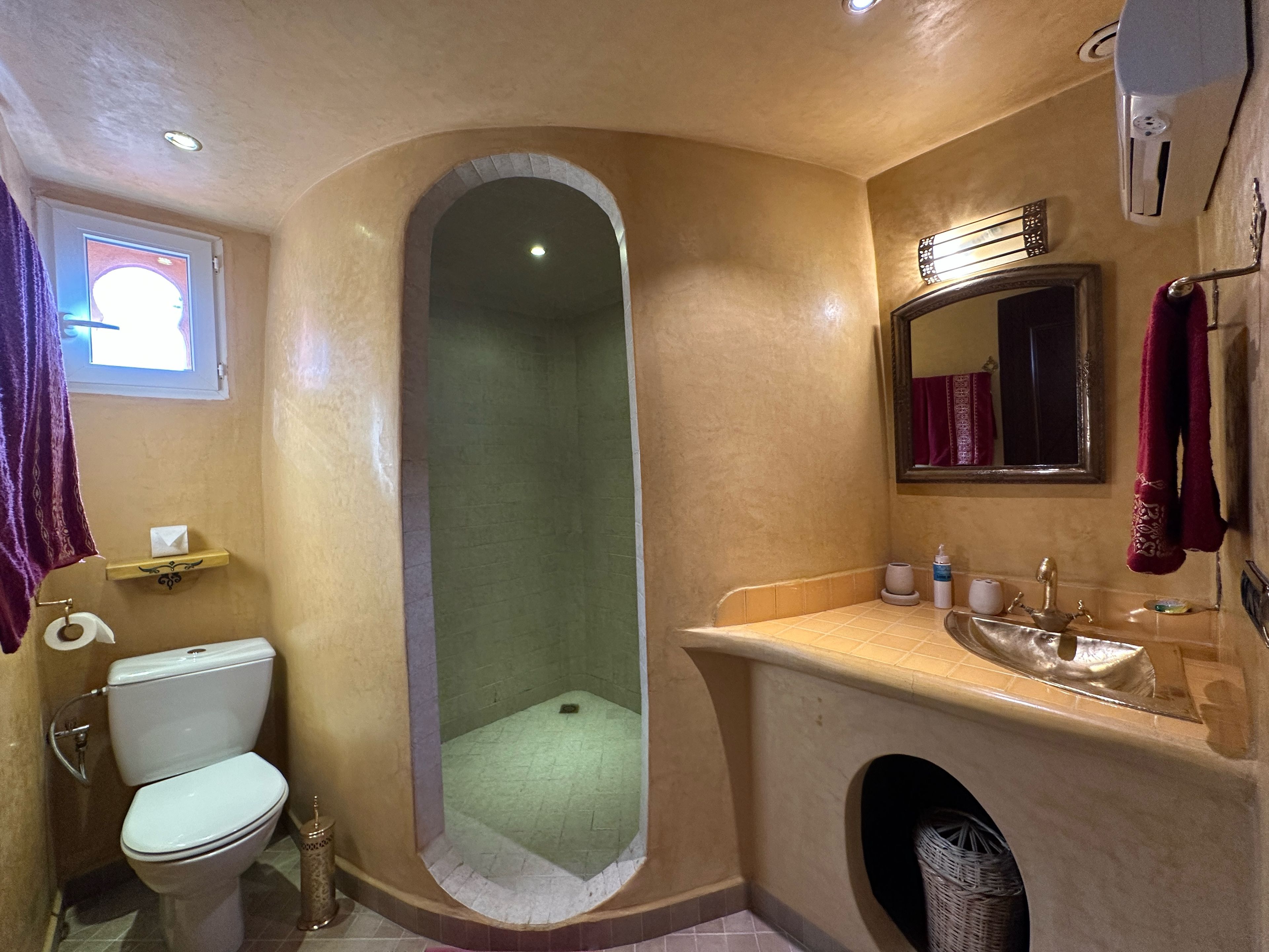 A bathroom with a toilet, sink, and shower area.