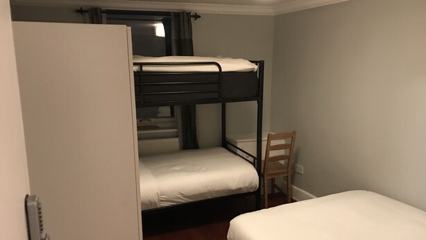 A bunk bed room with a single bed and a chair. - Rooms at 5 Hammersmith Road - Hostel (London)