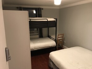 A bunk bed room with a single bed and a chair. - Rooms at 5 Hammersmith Road - Hostel (London)