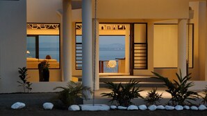 A modern building with a balcony overlooking a body of water. - Fiji Luxury Pool Villa 2 (Lautoka)