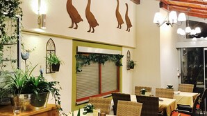 A restaurant with multiple tables and chairs, a wooden ceiling, and wall-mounted lights. - Hotel Werneths Landgasthof Hirschen (Rheinhausen)