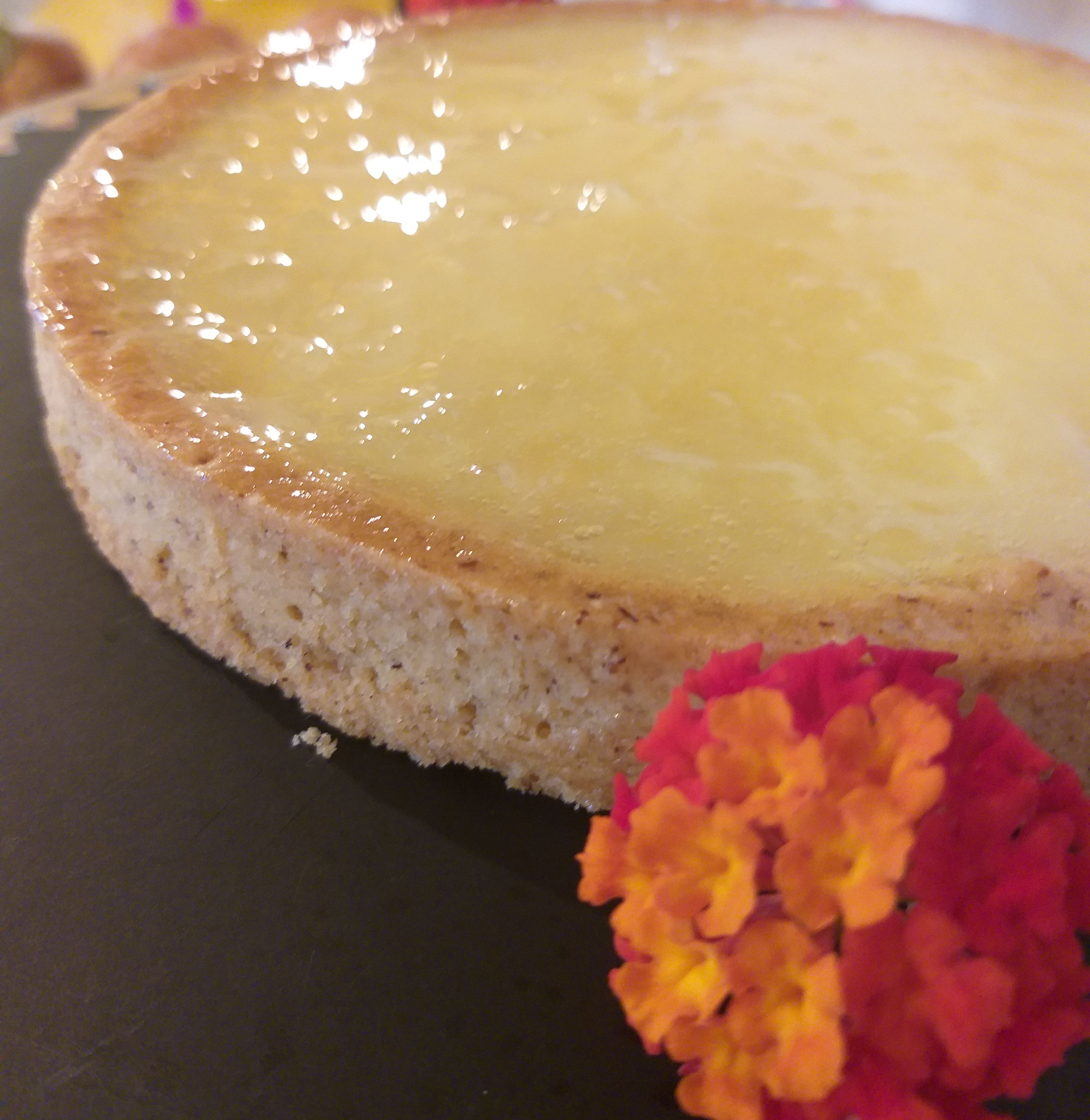 Een ronde cake met een glanzend bovenkant, op een donker oppervlak geplaatst.