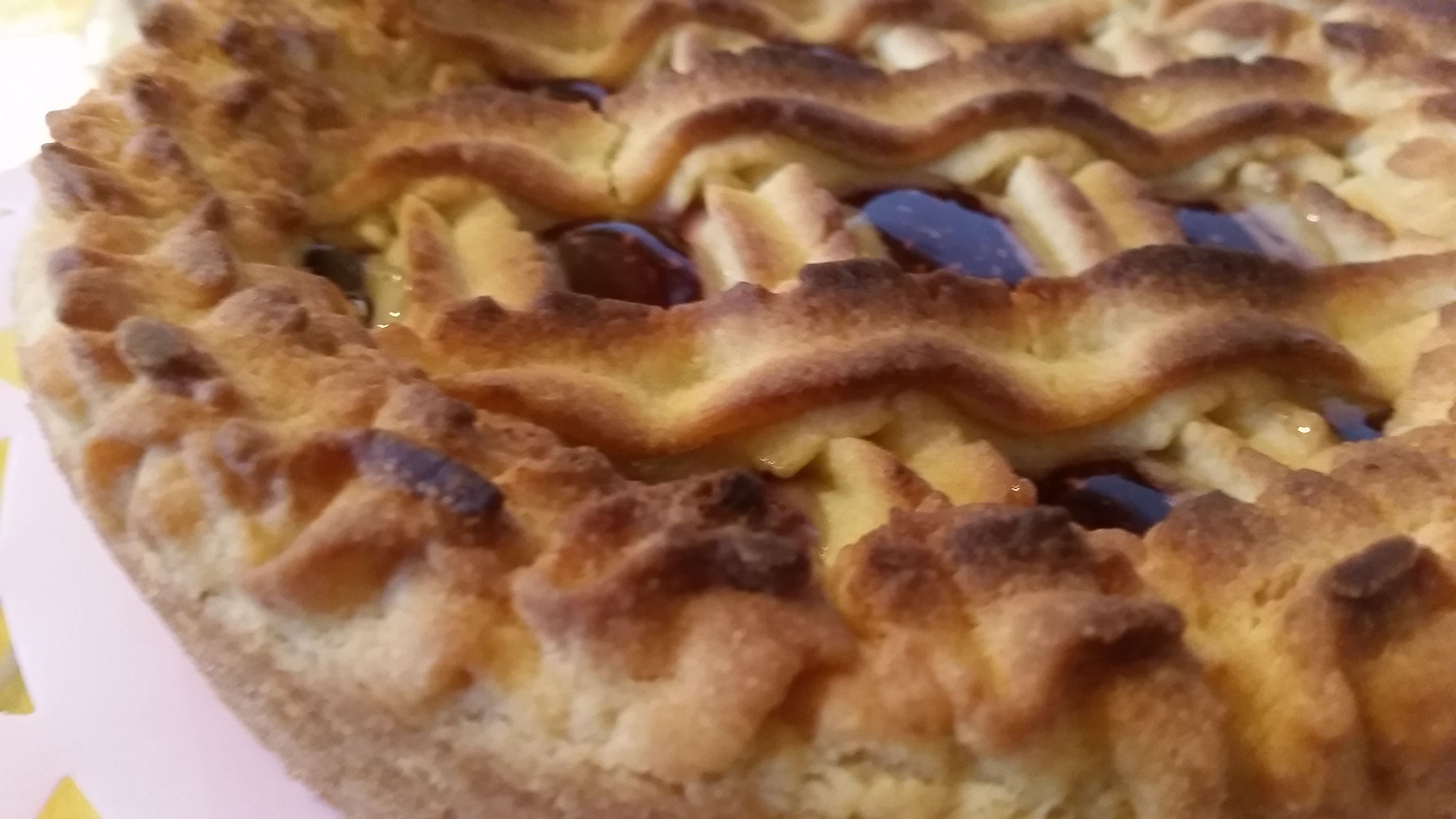 A close-up of a pie with a crimped edge and a golden-brown crust.