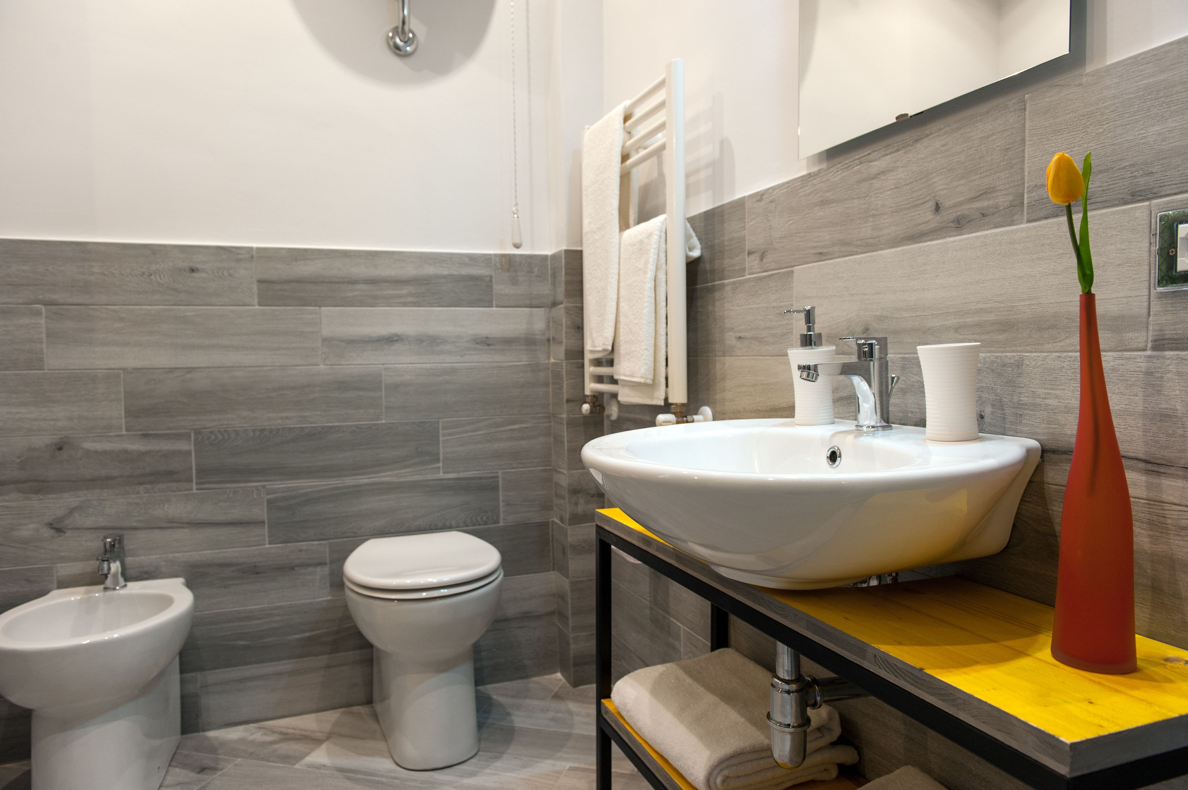 Un baño moderno con bidé, inodoro y lavamanos.