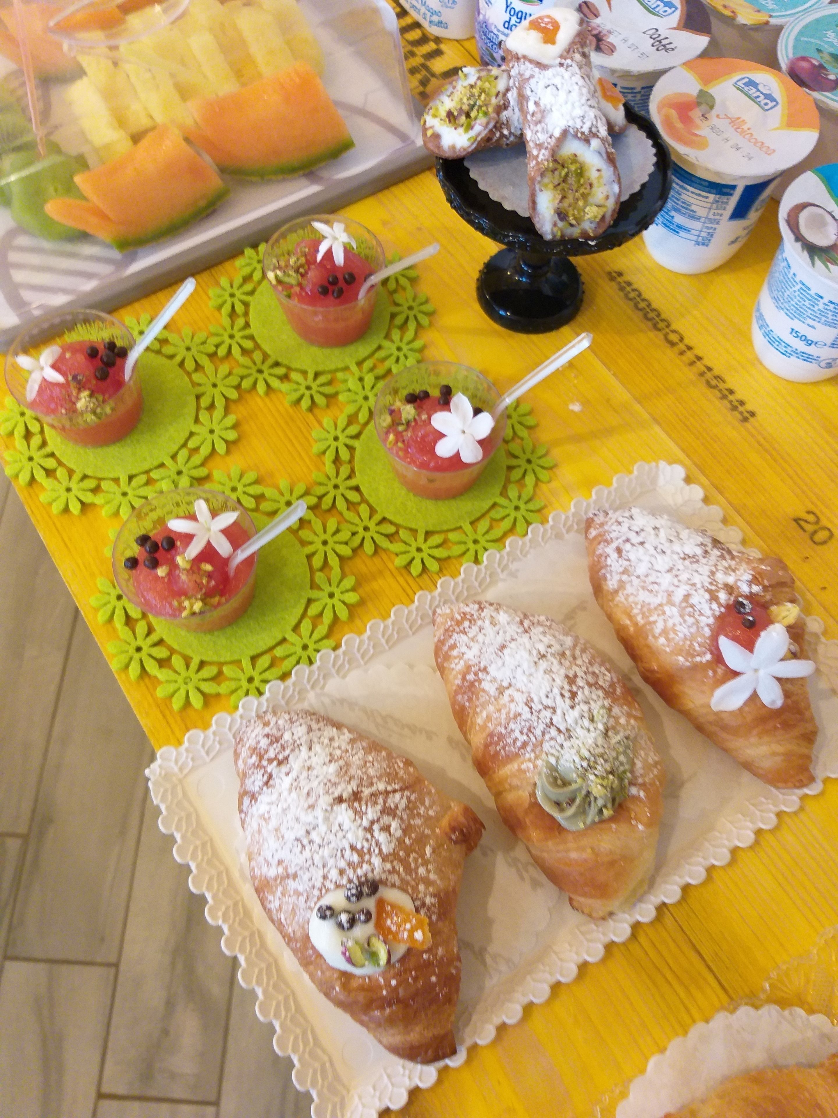 A table with various desserts, including pastries and fruit-based drinks.