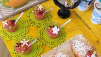 A table with various desserts, including pastries and fruit-based drinks.