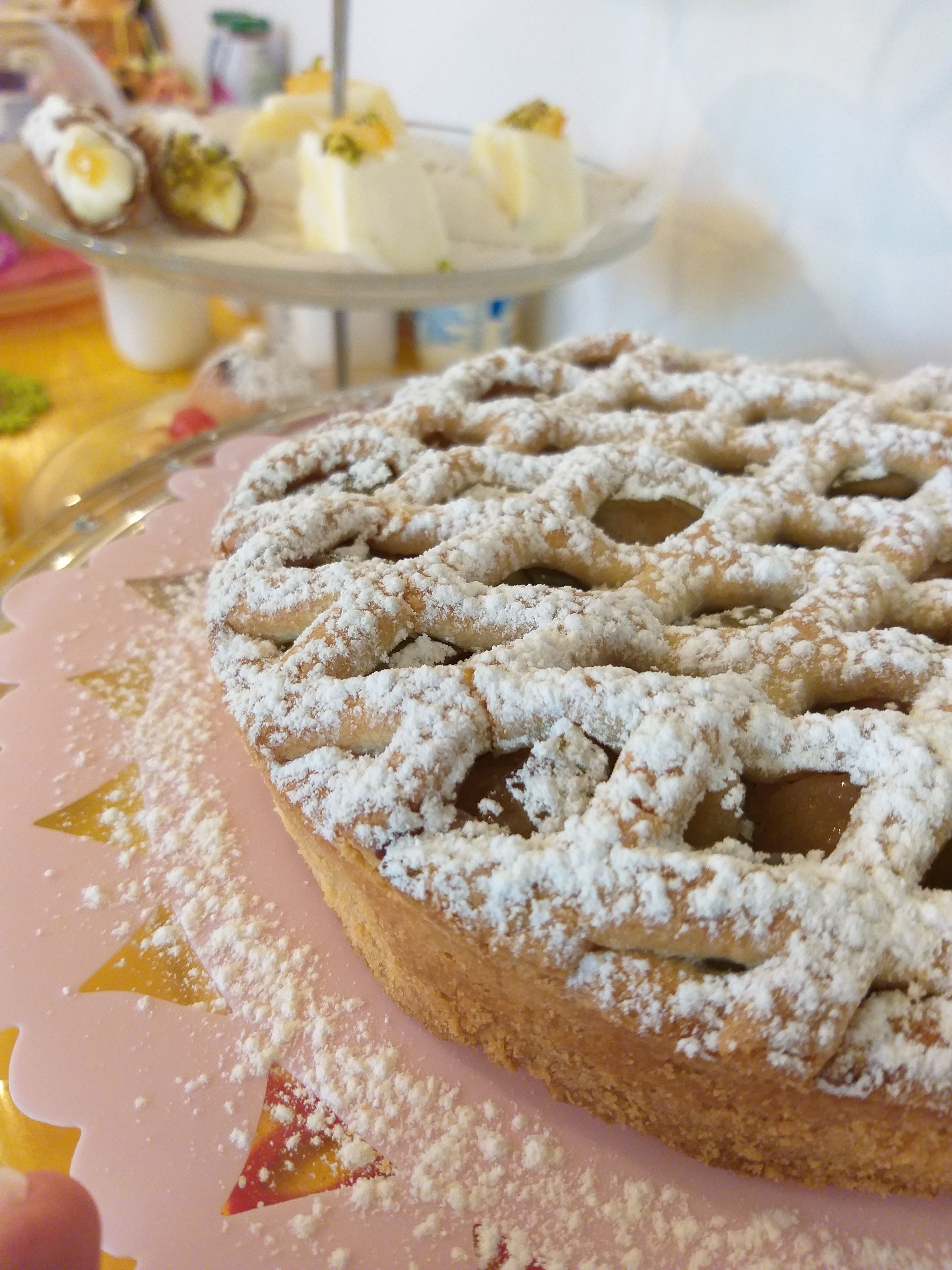 A dessert plate with a powdered pastry and a background of other desserts.